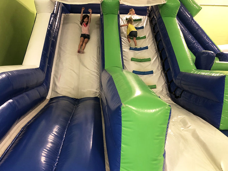 Catch Air girl going down inflatable slide