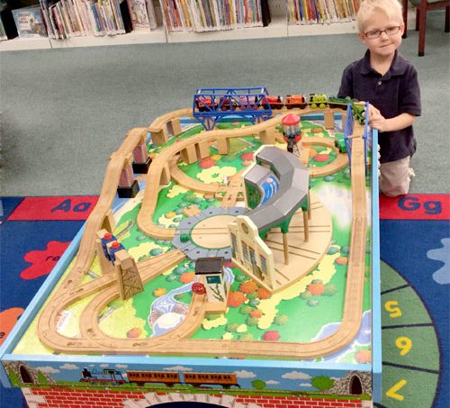 young boy at the train table at play area in the Walker Kent District Library branch KDL