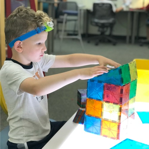 boy playing with Magnatiles at East Grand Rapids library