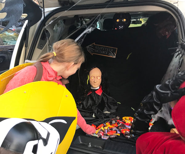 Trunk-or-Treat-Halloween girl getting treats from car trunk