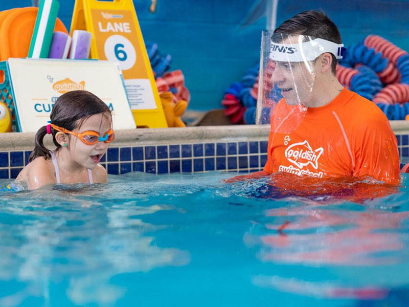 Goldfish swim instructor with student in pool