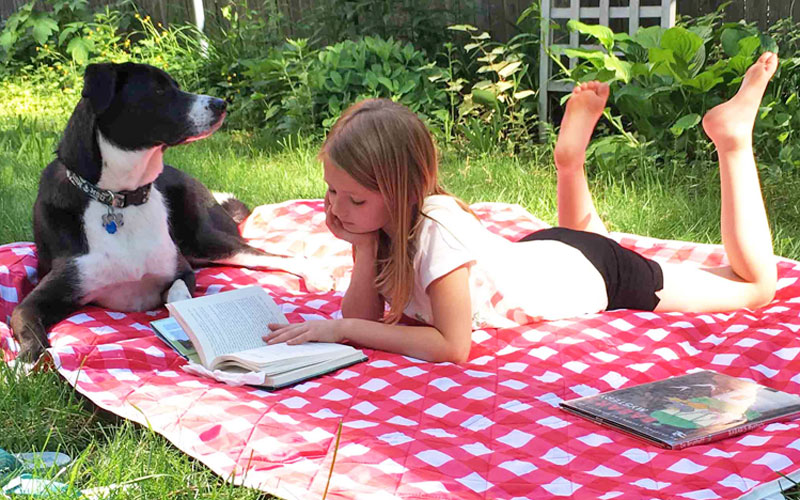 grand rapids summer reading enjoyed by girl and her dog