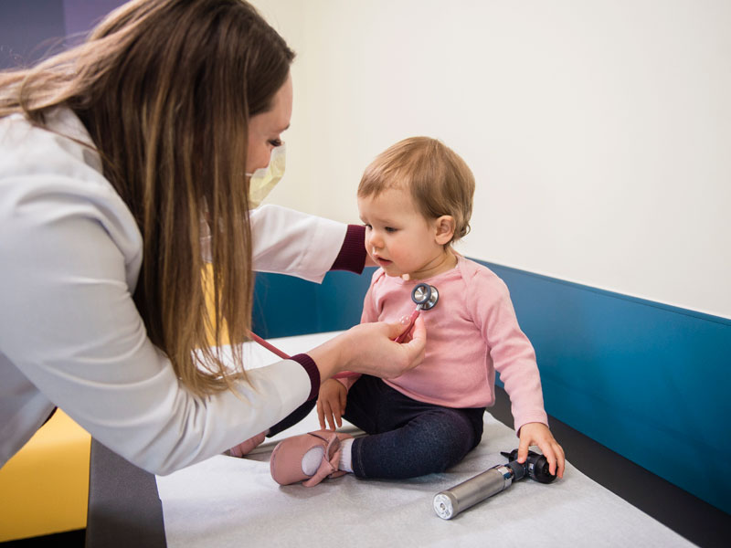 U M Health West pediatrician checking baby