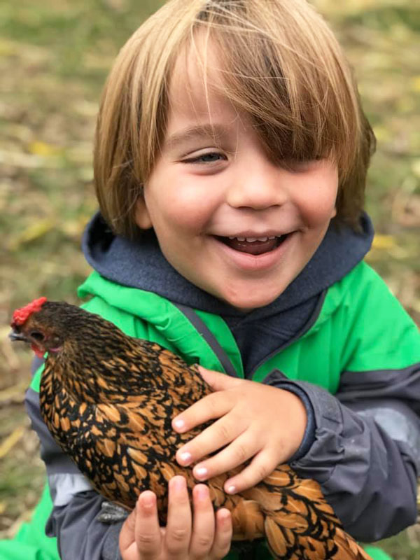 boy holding chicken at West Side Christian School