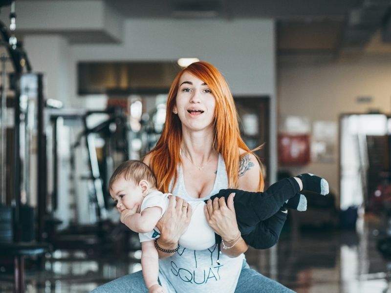 gyms with childcare mom lifting baby canva