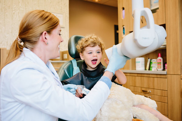 Pediatric Dental Specialists dentist looking at boys mouth