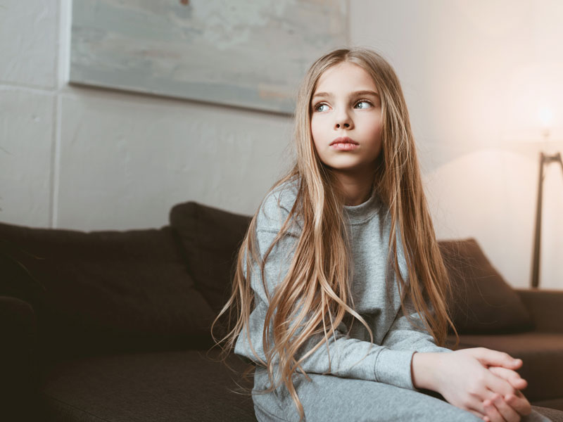 Young girl sitting on couch visiting with Child Therapist