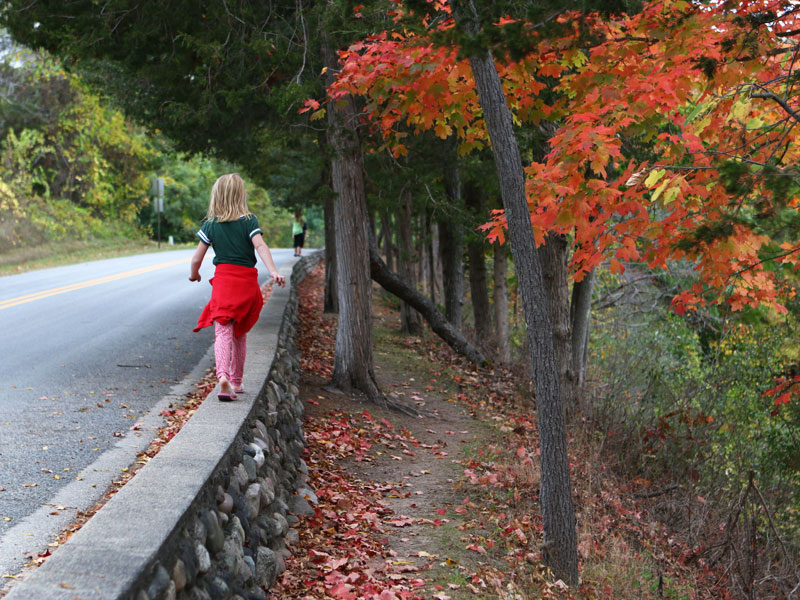 girl walking along wall at Fallasburg Park for fall pictures.