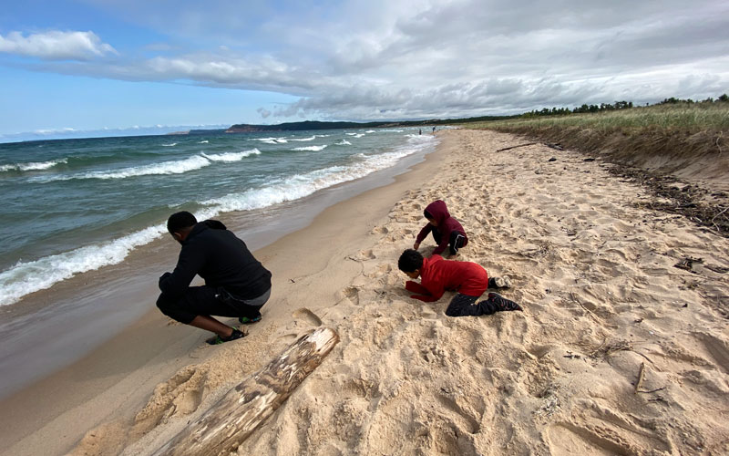 Peterson-Road-Beach-Sleeping Bear Dunes kids-looking-for-skipping-stones-with-their-dad