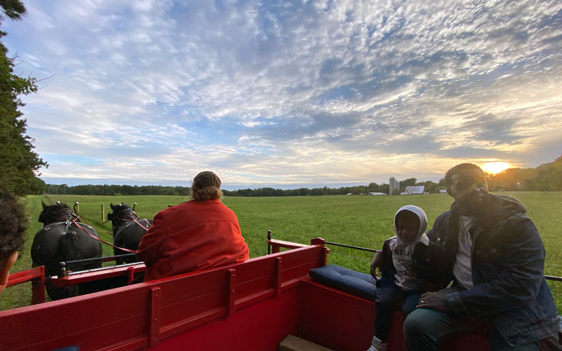 Wagon-Ride-at-sunset-with-Fantail-Farm-family-riding-in-wagon