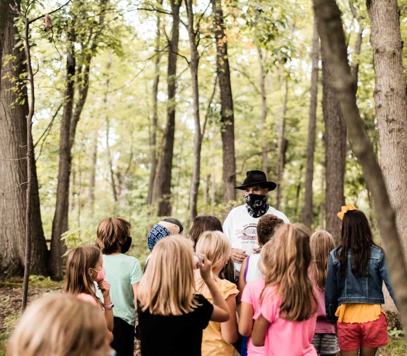 Rockford Christian School students and teacher outside in woods