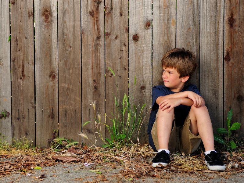 prevent child abuse neglect prevention lonely boy by fence