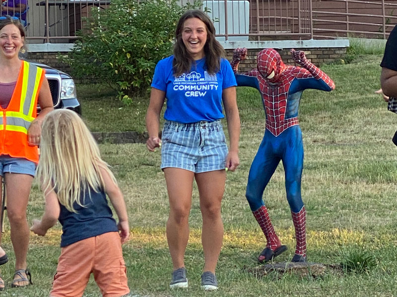 people dancing with Spiderman at movies in the park in Grand Rapids