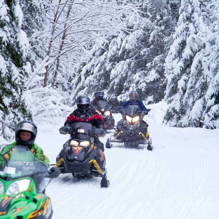 Group of friends snowmobiling in Michigan. 