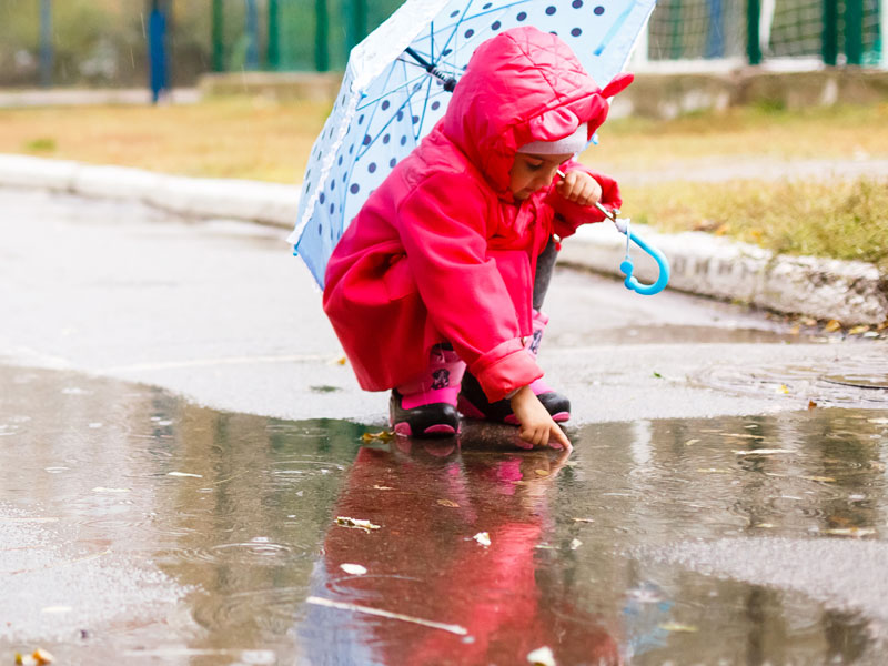Rainy day kid playing in puddle