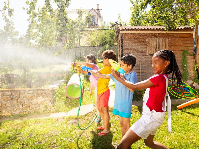 free summer fun kids playing with hose and squirt guns