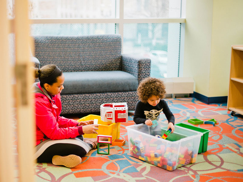 Caregiver and kid playing at GRPL library