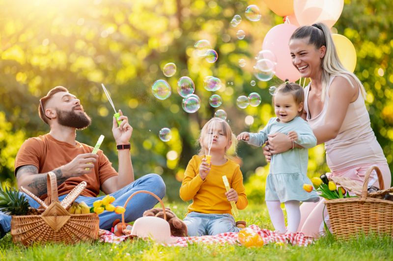Happy family resting in summer park.Cheerful family picnicking in the park.Summertime and vacation concept.