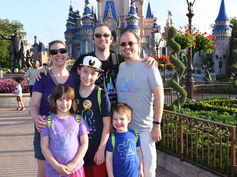 family in front of cinderella castle disney world travel agents