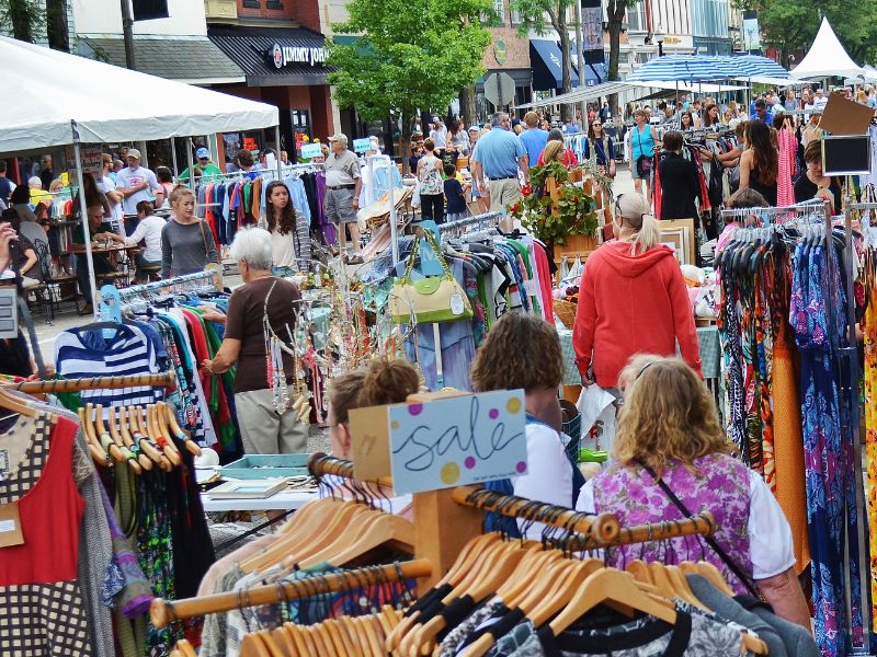 Downtown Holland Sidewalk Sale shoppers among racks