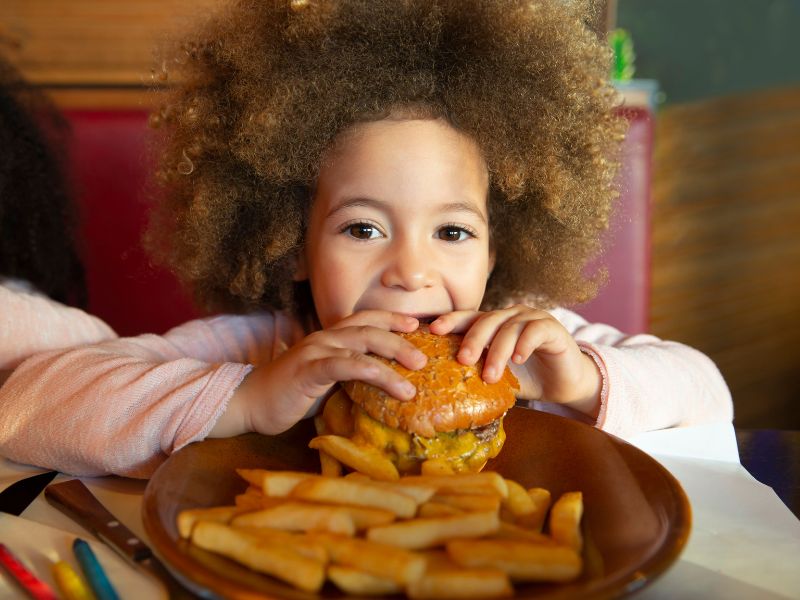 family restaurant kid friendly restaurant girl eating burger and fries