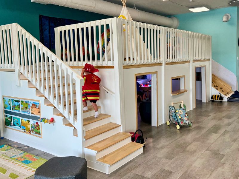 Stomping Grounds Play Cafe boy climbing stairs to play teepee