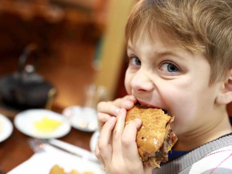 kids eat free boy eating burger canva radist getty images