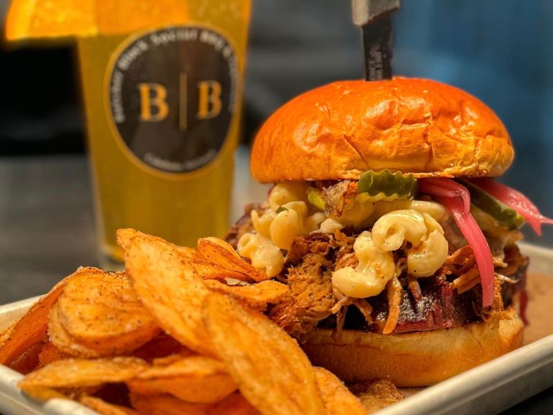 Butcher Block Social pork sandwich, chips, and beer - fb