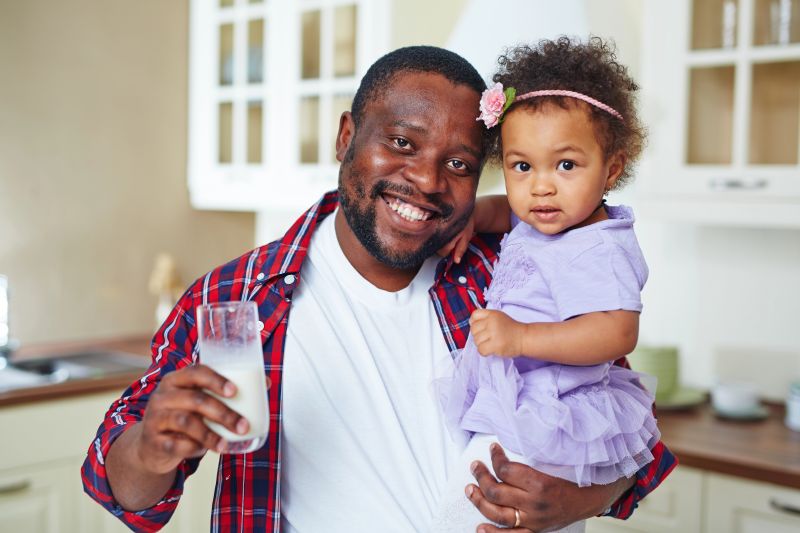 dad with toddler and glass of milk