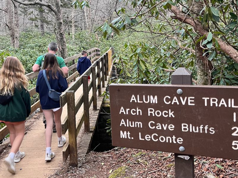 Things to do in the smoky mountains, family crossing a bridge on the trail to Alum Cave Bluffs