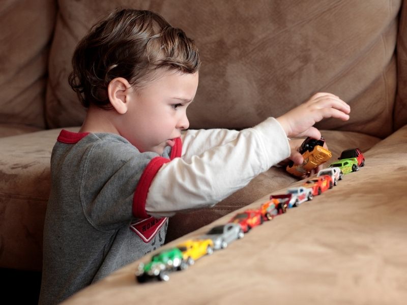 Autism boy lining up cars canva