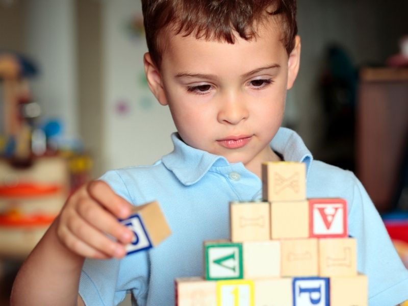 Autism testing boy building with blocks canva 
