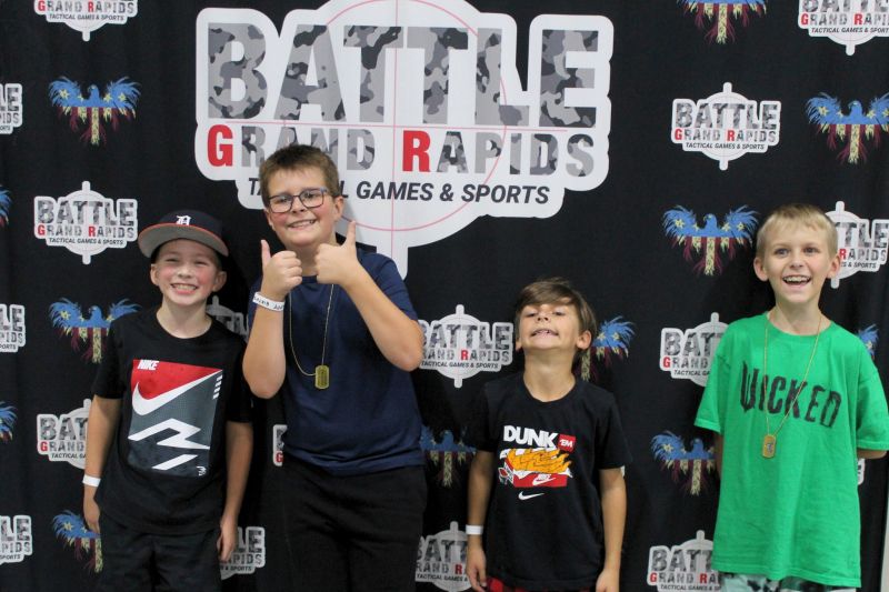 BattleGR boys in front of logo sign