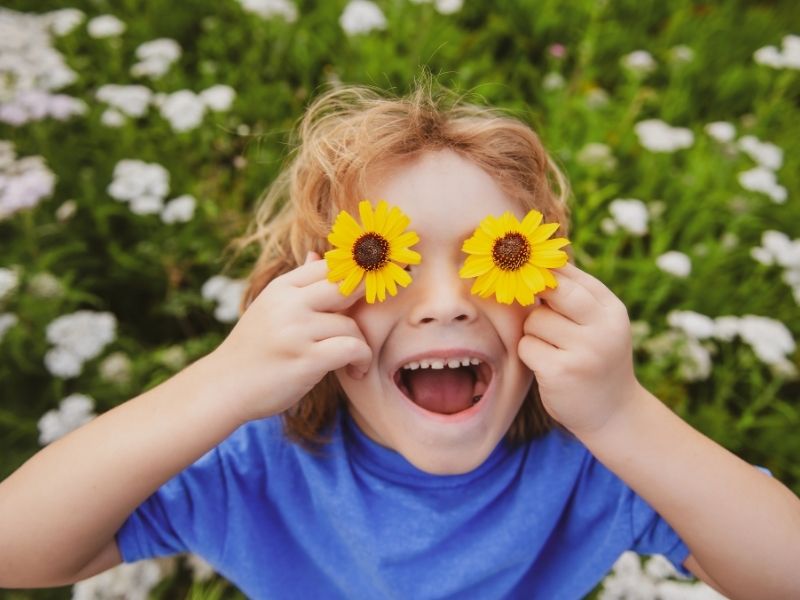 free spring activities boy with flowers over eyes
