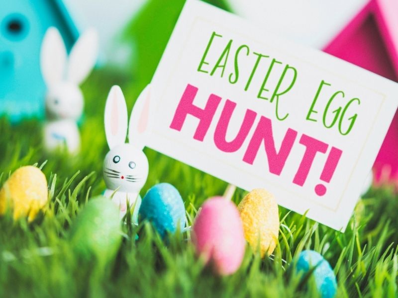 easter egg hunt sign with eggs and wooden bunnies canva 