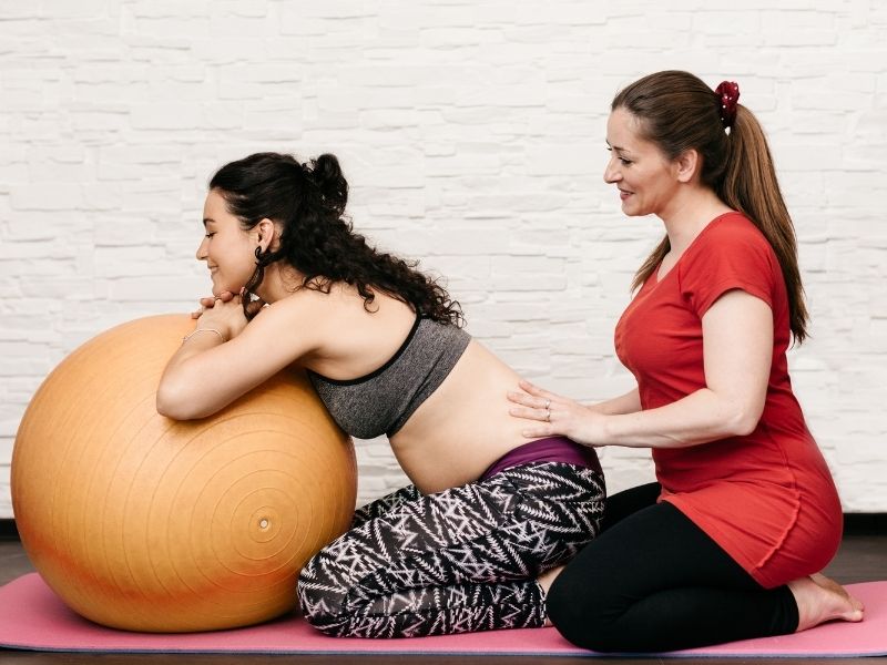 best midwife pregnant woman on exercise ball 
