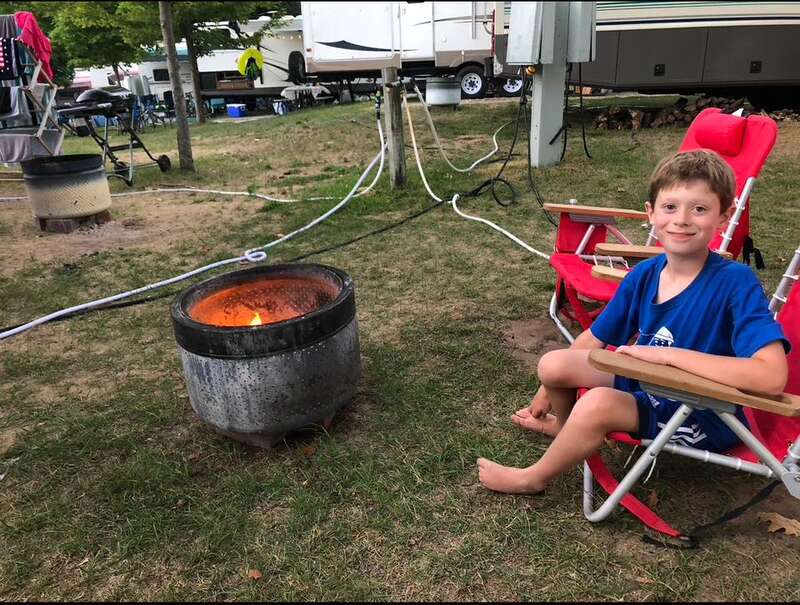 kid in red chair camping, firepit