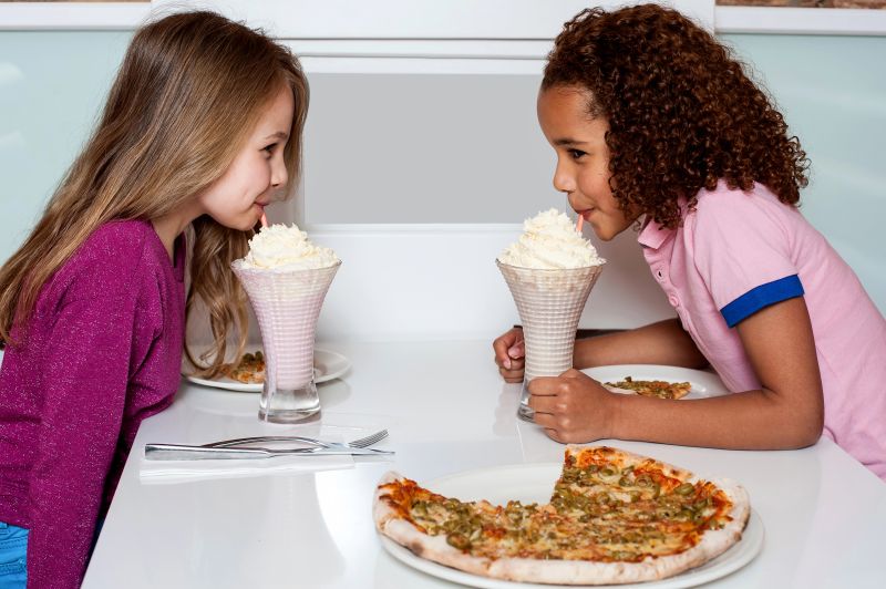 Girls Sipping Milkshakes And Eating Pizza