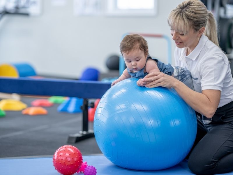 Baby With Physical Therapist Developmental Delay Canva FatCamera From Getty Images Signature