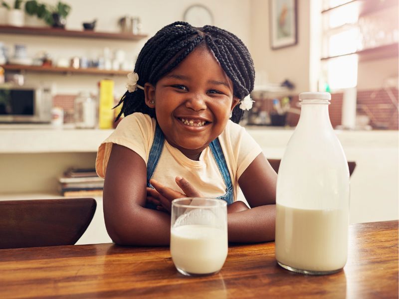 Girl drinking milk at table
